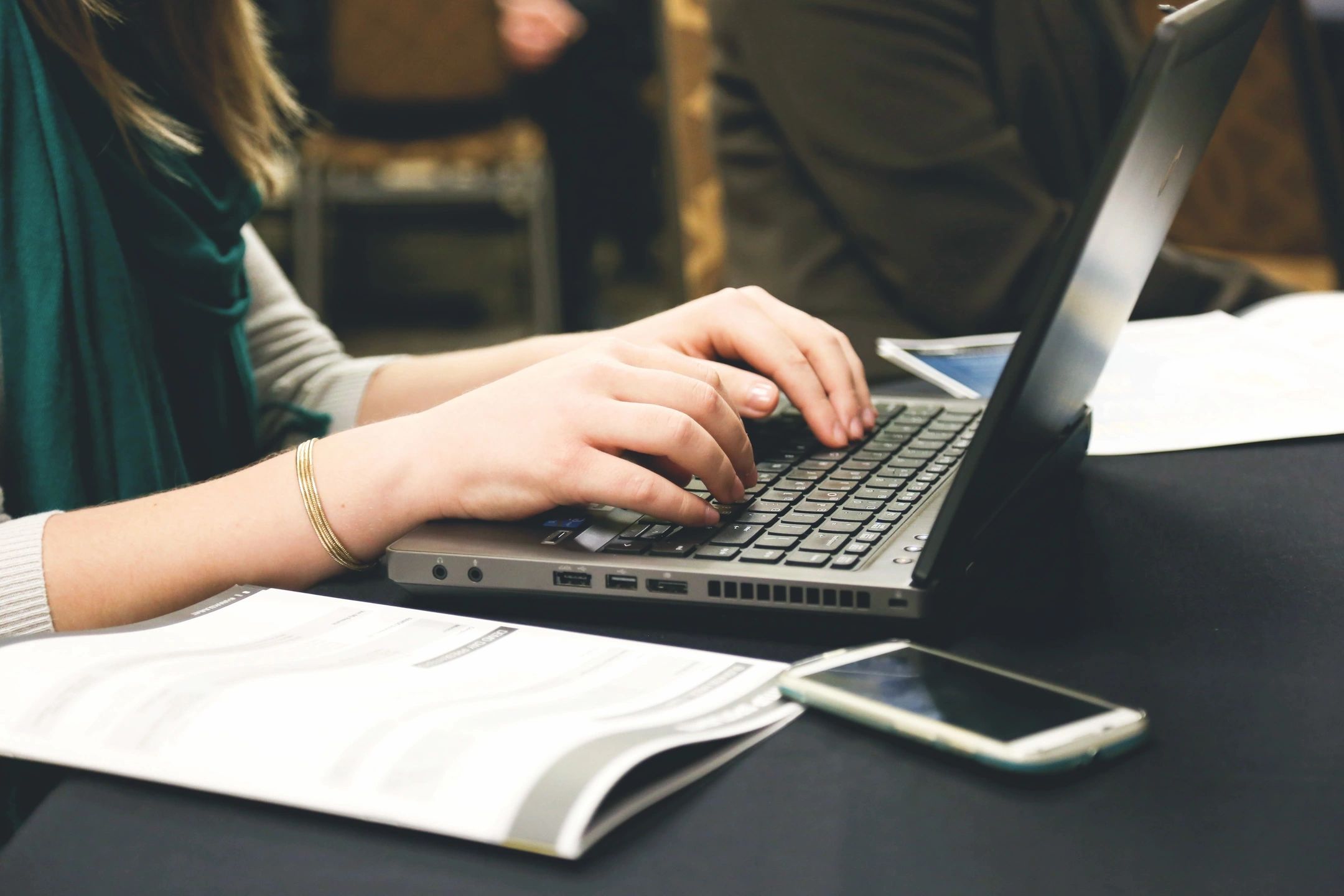 Close up of woman's hands on a laptop computer to depict writing.